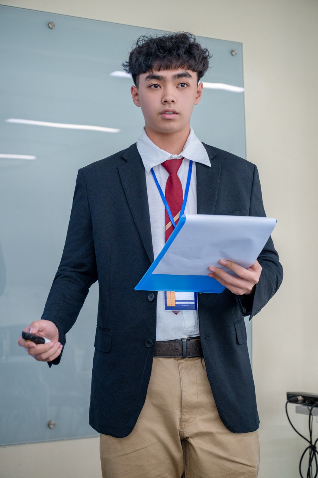 Trong Khang presenting in a navy blazer and red tie
